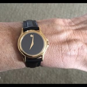 Ladies Gold Movado Watch black leather wrist band.